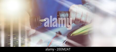 Elektroinstallateur hält Elektrostecker in der Hand; Mehrfachbelastung Stockfoto