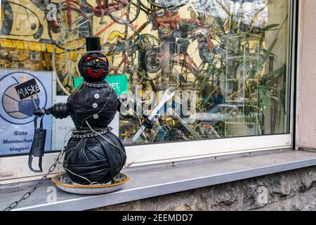 Lustige Figur vor Schaufenster von Fahrradladen in Kreuzberg, Reparaturwerkstatt, Hinweis auf Maskenpflicht während der Corona-Pandemie, Berlin-Kreuzb Stockfoto