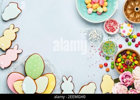 Ostern Backen Hintergrund. Ostern bunten Lebkuchen, Süßigkeiten und Süßwaren Topping Dressing auf blauem Hintergrund. Festliches Hintergrundkonzept Stockfoto