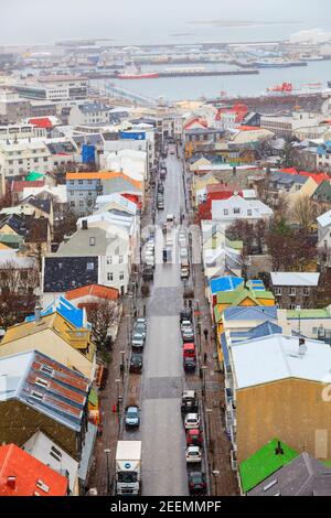 Vom Turm von Hallgrimskirkja aus hat man einen Blick auf die bunten Häuser und Gebäude in Richtung Hafen in Reykjavik, Island im Winter im Schnee Stockfoto