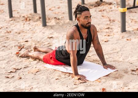 Junge afroamerikanische Athlet, tut Yoga Stretching Übungen Sonne Anrede Stockfoto