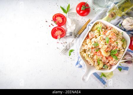 Frühlingsdiät gesunde vegane Pasta. Italienische Fusilli Pasta mit Tomaten, grünem Gemüse, frischen Kräutern, Frischkäse oder Feta, auf weißem Tischhintergrund c Stockfoto