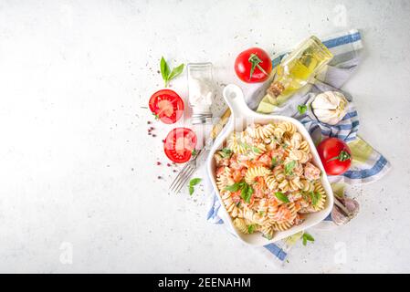 Frühlingsdiät gesunde vegane Pasta. Italienische Fusilli Pasta mit Tomaten, grünem Gemüse, frischen Kräutern, Frischkäse oder Feta, auf weißem Tischhintergrund c Stockfoto