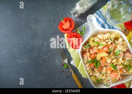 Frühlingsdiät gesunde vegane Pasta. Italienische Fusilli Pasta mit Tomaten, grünes Gemüse, frische Kräuter, Frischkäse oder Feta, auf dunklen Tisch Hintergrund Co Stockfoto