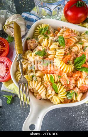 Frühlingsdiät gesunde vegane Pasta. Italienische Fusilli Pasta mit Tomaten, grünes Gemüse, frische Kräuter, Frischkäse oder Feta, auf dunklen Tisch Hintergrund Co Stockfoto