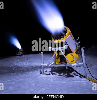 Celadna, Tschechische Republik - 01,12.2020: Schneekanone, die in der Nacht künstlichen Schnee erzeugen. Abgedunkelte Skiareal ohne Menschen. Stockfoto