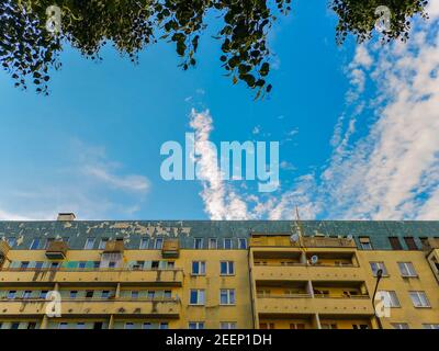 Wolkiger Himmel zwischen Ästen und bunten Wohngebäude in Breslau Stadt Stockfoto