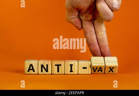 Anti-vax-Symbol. Doktor dreht Würfel mit den Worten 'Anti-vax'. Schöner orangefarbener Hintergrund. Speicherplatz kopieren. Business, medizinische covid-19 Impfung oder Anti-vax Stockfoto