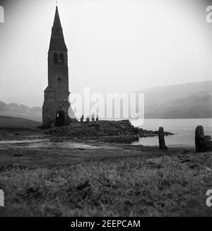 Archivfoto des Turms der Derwent Church, Derbyshire. Das Dorf Derwent wurde abgerissen, um das Ladybower Reservoir zu schaffen, um Haushaltswasser für Sheffield und Derbyshire zur Verfügung zu stellen. Ursprünglich wurde der Turm der abgerissenen Derwent Kirche aus der Oberfläche des Wassers stochend gehalten, aber die Entscheidung wurde getroffen, es am 15. Dezember 1947 zu sprengen, als, Wie man an diesen dramatischen Fotos sehen kann, die von einem unbekannten Fotografen aufgenommen wurden, als der Wasserstand im Stausee niedrig war, gingen oder schwanen die Besucher häufig hinüber, um die Ruinen zu erkunden. Stockfoto