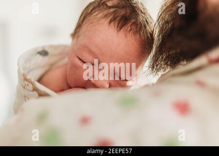 Nahaufnahme des neugeborenen Gesichtes, das auf neuem Vater ruht Stockfoto