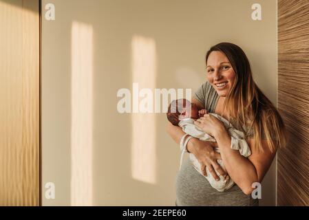 Neugeborener Junge, der meine Mutter im Krankenhaus festgehalten hat Stockfoto