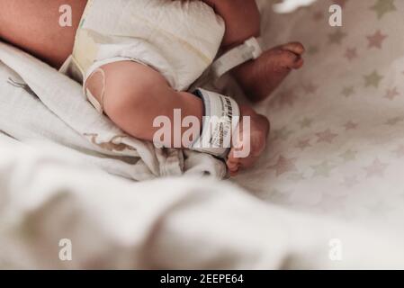 Nahaufnahme der neugeborenen Füße mit Krankenhausarmband Stockfoto