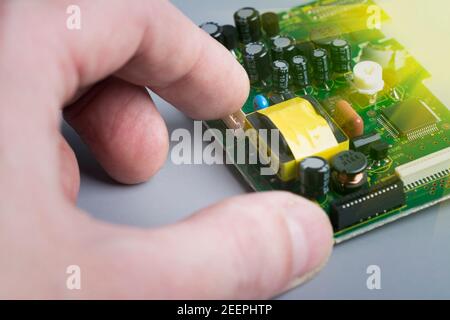 Techniker halten die leiterplatte in der Hand. Elektronische Komponenten auf Leiterplatte drucken. Technische Unterstützung und Reparatur. Dienstleistungen Für Die Elektronikfertigung Stockfoto