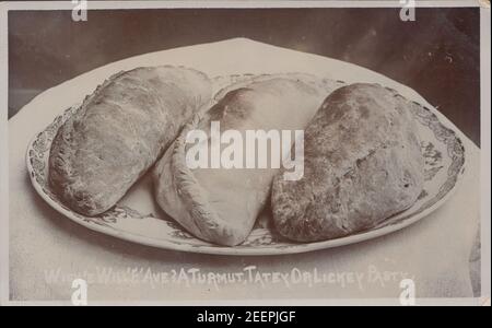 Jahrgang Anfang 20th Jahrhundert Fotokarte zeigt drei Cornish Pasties auf einem Teller. Stockfoto