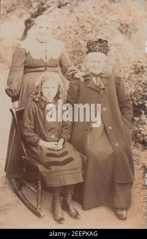 Jahrgang Anfang 20th Jahrhundert fotografische Postkarte zeigt zwei Damen und ein Mädchen. Möglicherweise drei Generationen derselben Familie. Stockfoto