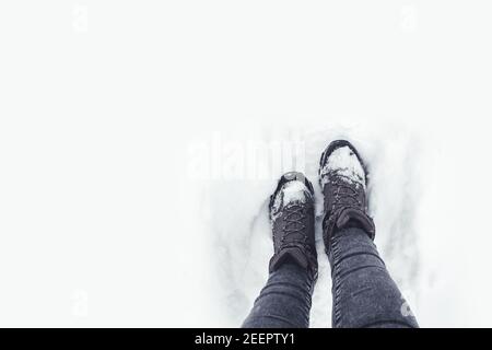 Wandern auf schneebedecktem Boden. Wanderschuhe mit Schnee bedeckt. Outdoor-Aktivitäten im Winter Stockfoto