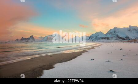 Wintersonnengang über der Küste und den Bergen, farbenprächtiger Sonnenaufgang im Norden und Sonnenlicht in rosa Wolken. Lofoten-Inseln, Norwegen, Europa Stockfoto