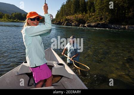 Joanne Linehan landet mit ihrem Mann Tim eine große Forelle, bevor sie sie wieder in den Kootenai River freigibt. Lincoln County, MT (Foto von Randy Beacham) Stockfoto