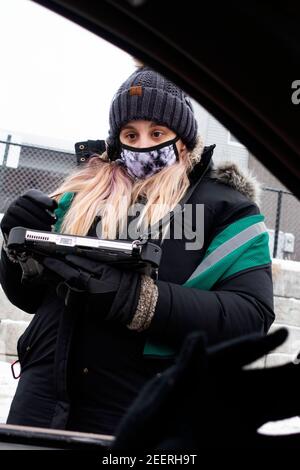 Maskierte Frau, die während der Covid Pandemie bei frigidem Wetter einen Kaffee im Starbucks Drive-Thru bestellt hat. St. Paul Minnesota, USA Stockfoto