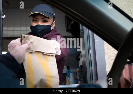 McDonald's-Mitarbeiter im Lebensmitteldienst maskierte, während der Pandemie COVID-19 Lebensmittel an den Kunden im Auto zu übergeben. St. Paul Minnesota, USA Stockfoto