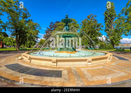 Springbrunnen Four Seasons im Zentrum von Jardin Anglais und Promenade du Lac in Genf, Schweiz. Genfersee, Uferpromenade und Bucht im Hintergrund. Stockfoto