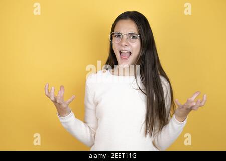 Schönes Kind Mädchen tragen lässige Kleidung verrückt und verrückt schreien und schreien mit aggressivem Ausdruck und Arme angehoben. Frustration Konzept. Stockfoto