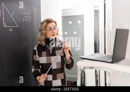 Junge Mathematiklehrerin erklärt Geometrie. Online arbeiten. Stockfoto