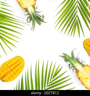 Rahmen aus Ananas und Mangofrüchten mit Palmblättern auf weißem Hintergrund. Flach liegend, Draufsicht. Stockfoto