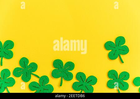 St. Patricks Day Hintergrund. Einfach minimalistisches Design mit grünem Kleeblatt. Kleeblätter isoliert auf gelbem Hintergrund. Symbol von Irland. Glück w Stockfoto