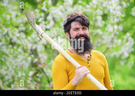 Glücklicher Mann im Frühlingsgarten. Gärtner in Öko-Farm mit Gartengeräten Pflanzen mit Schaufel. Stockfoto