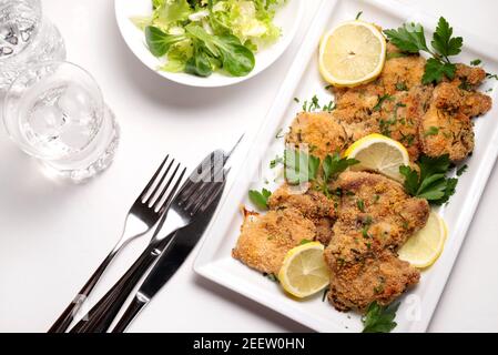 Hähnchenschnitzel auf einem weißen Teller auf dem Tisch. Draufsicht. Stockfoto