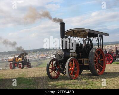 Eine schöne Szene auf der großen dorset Dampfmesse mit Zwei Dampfstraßenlokomotiven fahren auf einem Hügel am Großes Festivalgelände im Sommer Stockfoto