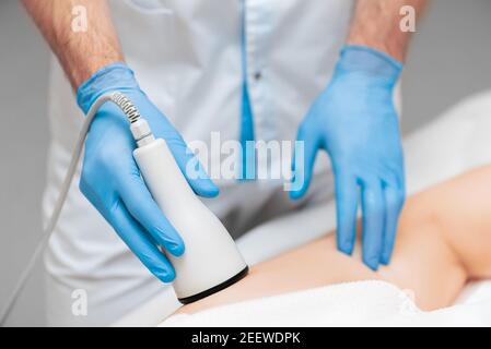 Ultraschall-Massage Nahaufnahme auf dem Oberschenkel der Frau. Moderne Hardware-Kosmetik. Stockfoto