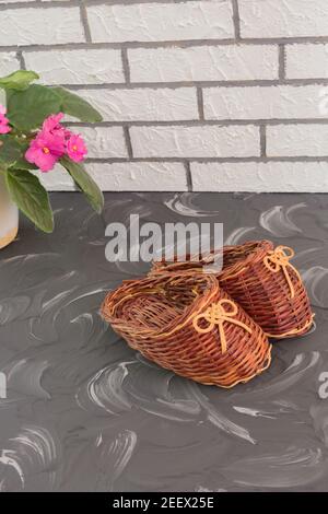 Dekorative Schmuckschuhe aus natürlichem Weinstock gewebt. Von Hand gefertigt, selektiver Fokus. Stockfoto