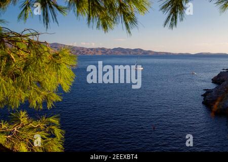 Idyllischer Blick auf ein Segelboot (kein Segel), das in der Nähe der griechischen Insel Hydra segelt. Im Hintergrund ist das Festland Griechenland. Sommersonntag! Stockfoto