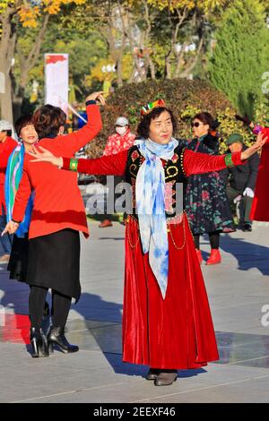 Tänzer in uigurischer Kleidung am Hauptplatz der Stadt. Zhangye-Gansu-China-1237 Stockfoto