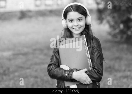 Mädchen hören Audio tragen Lehrbücher auf dem Weg zur Schule, Schule Club Konzept. Stockfoto