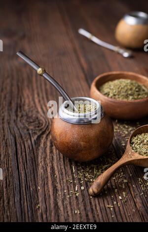 Gesundes Getränk, klassischer Yerba Mate Tee in einem Kürbis mit Mobilla auf Holzhintergrund Stockfoto