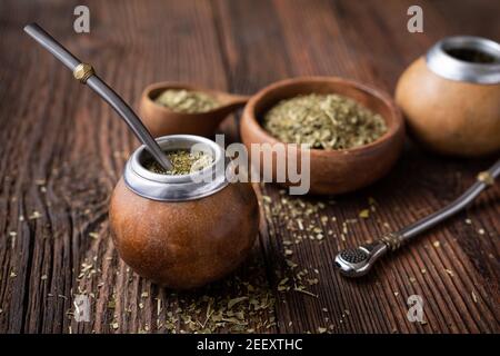 Gesundes Getränk, klassischer Yerba Mate Tee in einem Kürbis mit Mobilla auf Holzhintergrund Stockfoto