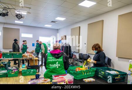 Freiwillige bei einer Trussell Trust Foodbank sammeln, sortieren und organisieren gespendete Lebensmittel, die an die lokale Gemeinschaft in Colindale UK gegeben werden Stockfoto