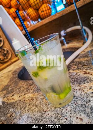 Mojito trinken in hohem Glas mit zerdrücktem Eis hinter gefüllt Bar Stockfoto