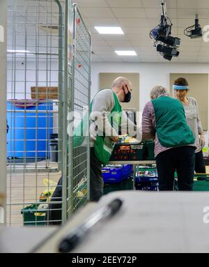 Freiwillige bei einer Trussell Trust Foodbank sammeln, sortieren und organisieren gespendete Lebensmittel, die an die lokale Gemeinschaft in Colindale UK gegeben werden Stockfoto