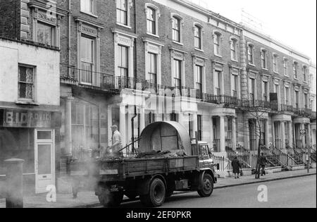 Großbritannien, West London, Notting Hill, 1973. Heruntergekommene und heruntergekommene, große, vierstöckige Häuser werden langsam restauriert und neu dekoriert. No,229 Westbourne Park Road. Straßenreparaturen. Stockfoto