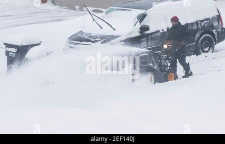 Mississauga, Kanada. Februar 2021, 16th. Ein Mann benutzt ein Schneegebläse, um seine Auffahrt in Mississauga, Ontario, Kanada, am 16. Februar 2021 zu räumen. Ein Wintersturm traf die Stadt Toronto und Umgebung am Dienstag. Quelle: Zou Zheng/Xinhua/Alamy Live News Stockfoto