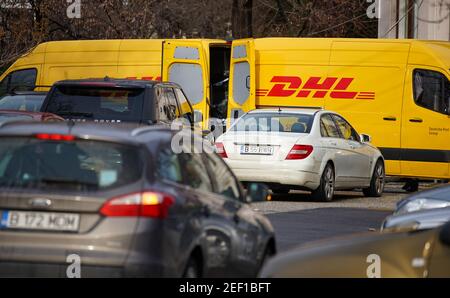 Bukarest, Rumänien - 25. januar 2021 zwei gelbe DHL Lieferwagen werden gesehen, wie sie Pakete auf einer Straße in Bukarest umstellen. Dieses Bild ist für editoria Stockfoto