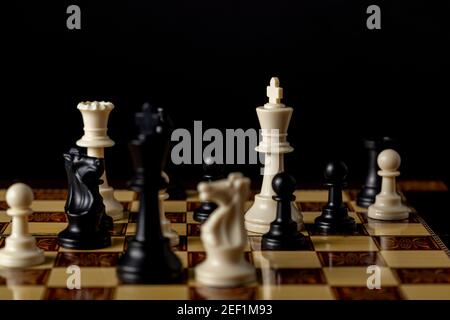 Bild zeigt ein laufendes Schachspiel mit einer späten Spielposition. Vielseitiges Image für Wettbewerb, Ehrgeiz, Kampf, Niederlage, Sieg, Strategiekontra Stockfoto