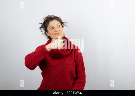 Junge schöne Frau trägt Pullover und zeigt mit dem Finger auf Die Seite Stockfoto