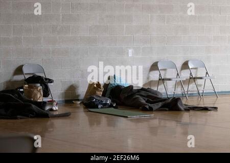 Austin, Texas, USA. Februar 2021, 16th. Austin, Texas 16. Februar 2021: Ein Obdachloser, der vor der extremen Kälte des texanischen Schneesturms flieht, schläft in einer von der Kirche betriebenen Notklinik in Austin. Ein historischer Schnee von 8 Zoll gepaart mit bitterkalten Temperaturen haben Hunderte von Menschen gezwungen, sich im Freien zu beherbergen. Quelle: Bob Daemmrich/ZUMA Wire/Alamy Live News Stockfoto