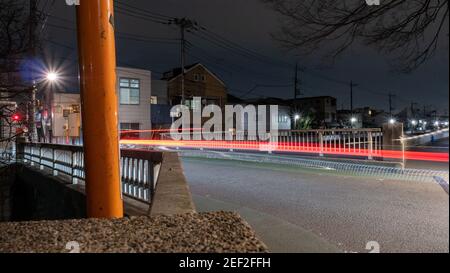 Eine leichte Spur Bild eines Autos überquert eine Brücke in der Nacht in Vorstadt Tokio. Stockfoto