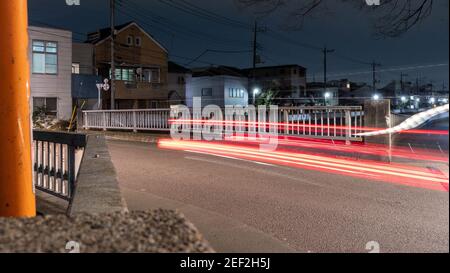 Eine leichte Spur Bild eines Autos überquert eine Brücke in der Nacht in Vorstadt Tokio. Stockfoto